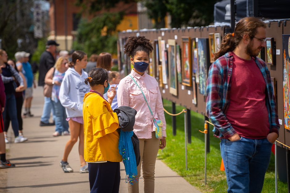 people looking at art work on the fence line during the 2021 Arts festival