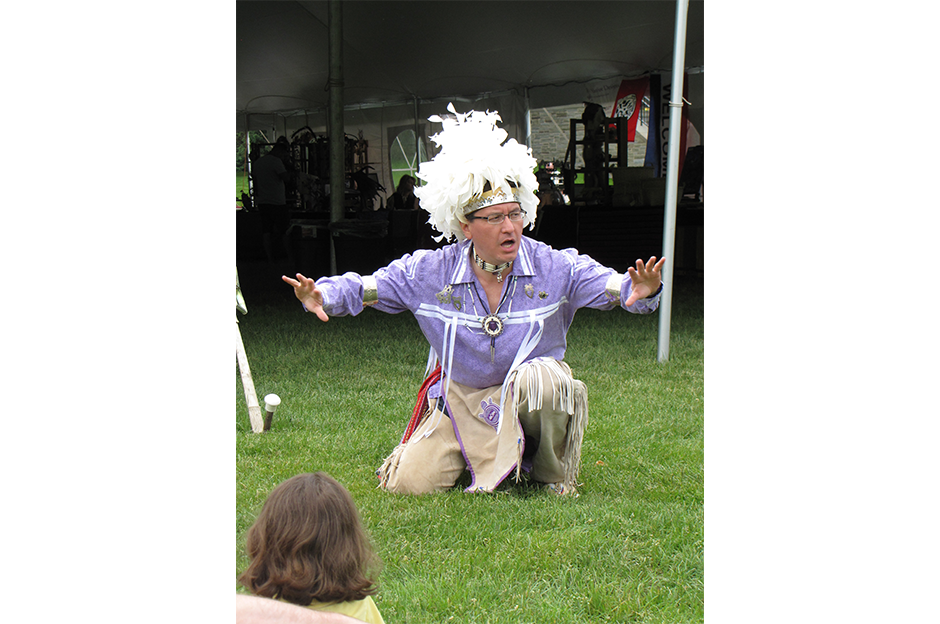 man dressed in native american clothing doing dance