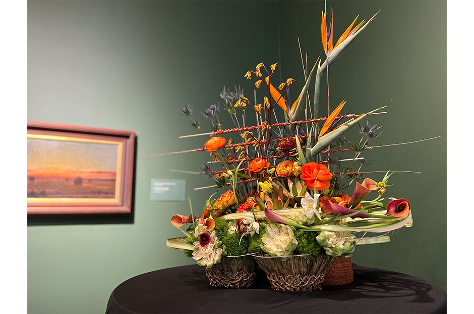 floral display with artwork behind it