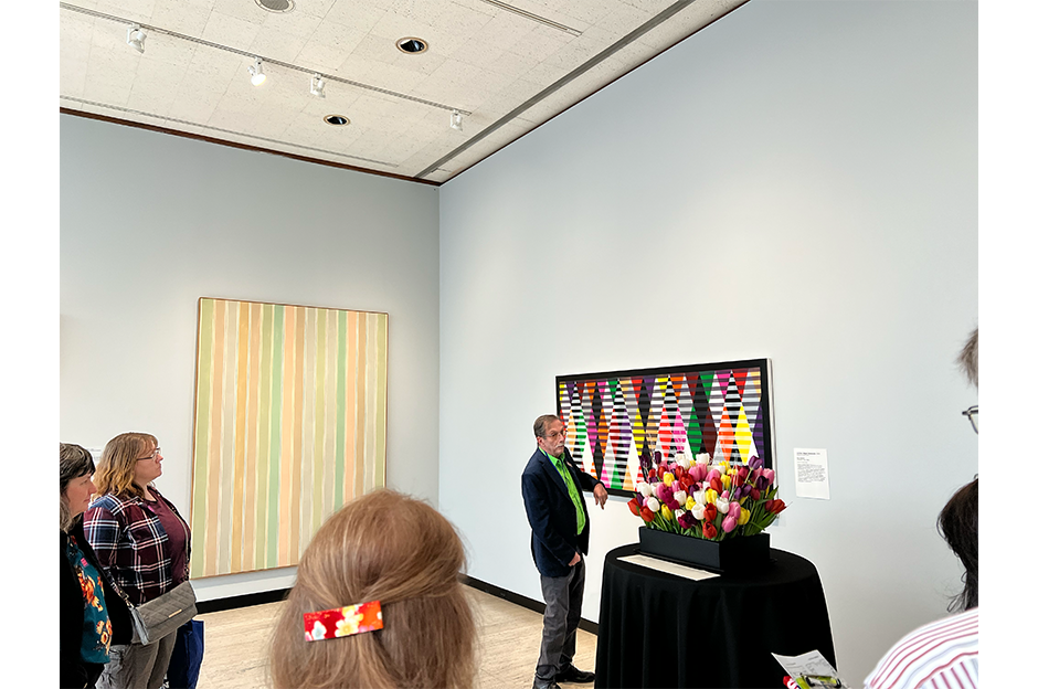 people standing in museum looking at artwork and floral design conception next to it