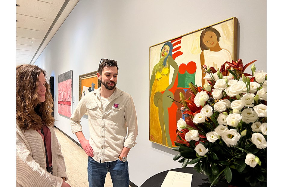 people standing in museum looking at artwork and floral design conception next to it