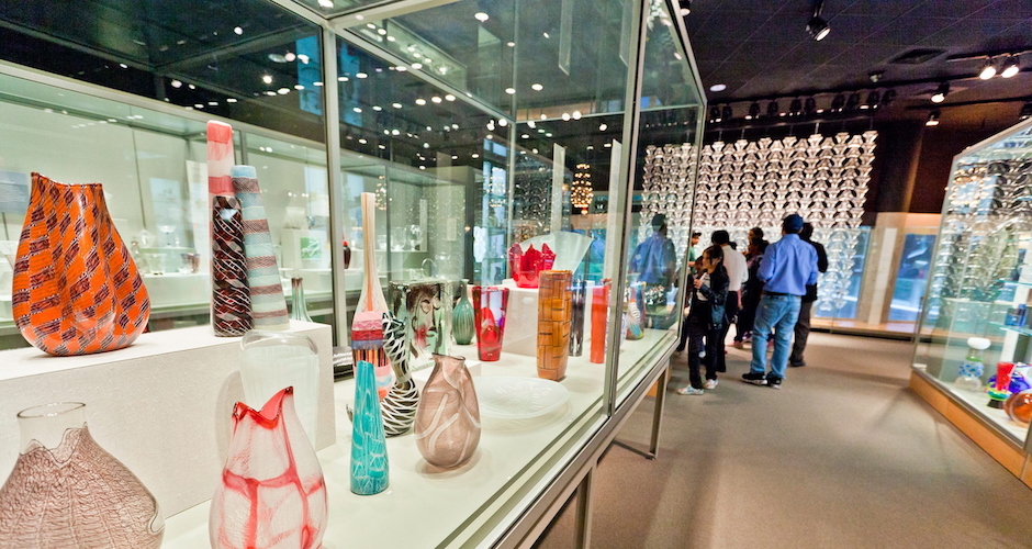 people looking at glass art in museum