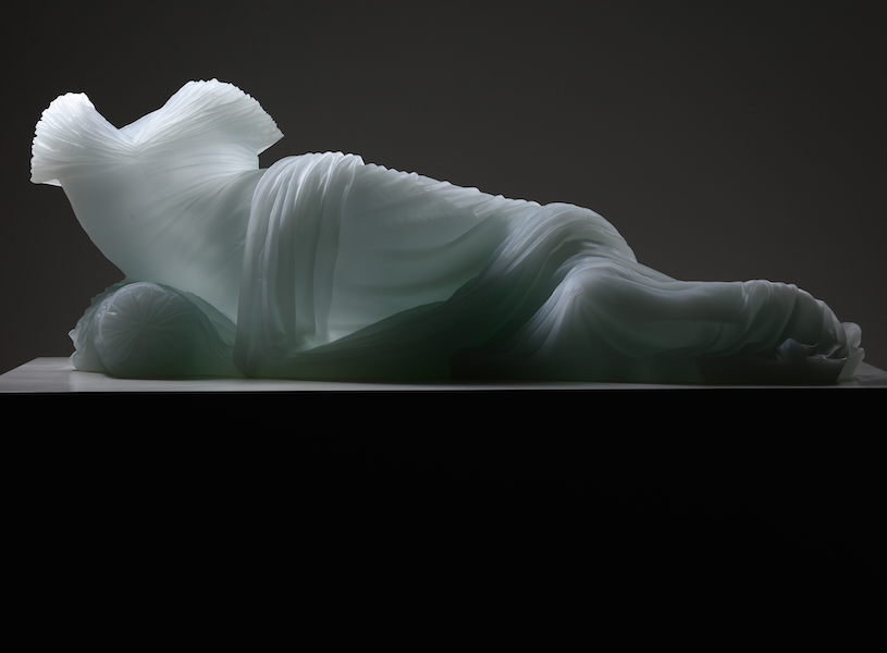 Form of woman laying, just glass dress providing form