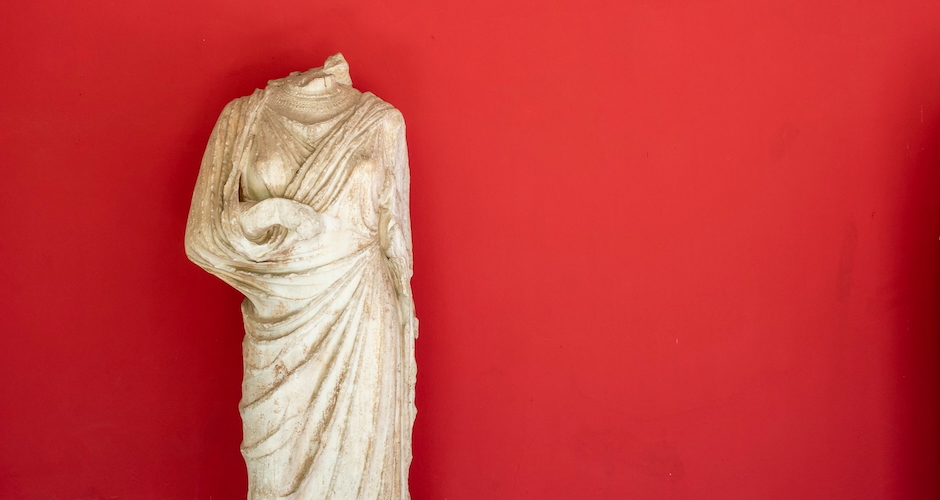 roman female statue in a toga on a red background
