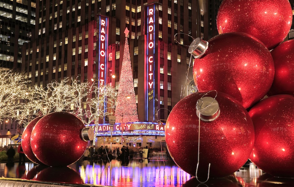 Radio City, surrounded by huge ornaments on water reflecting all the lights 