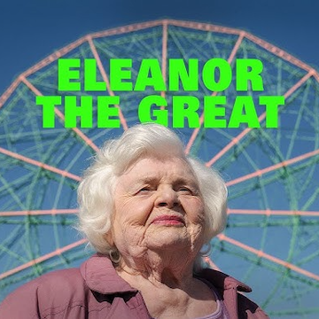 elderly woman smiling in front of a ferris wheel
