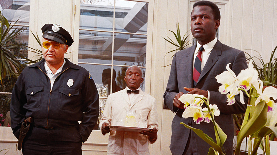 Man standing in waiting room with flowers with a butler and a cop