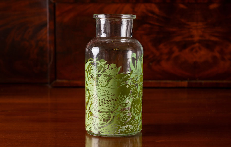 glass jar with grean bird a flora pattern