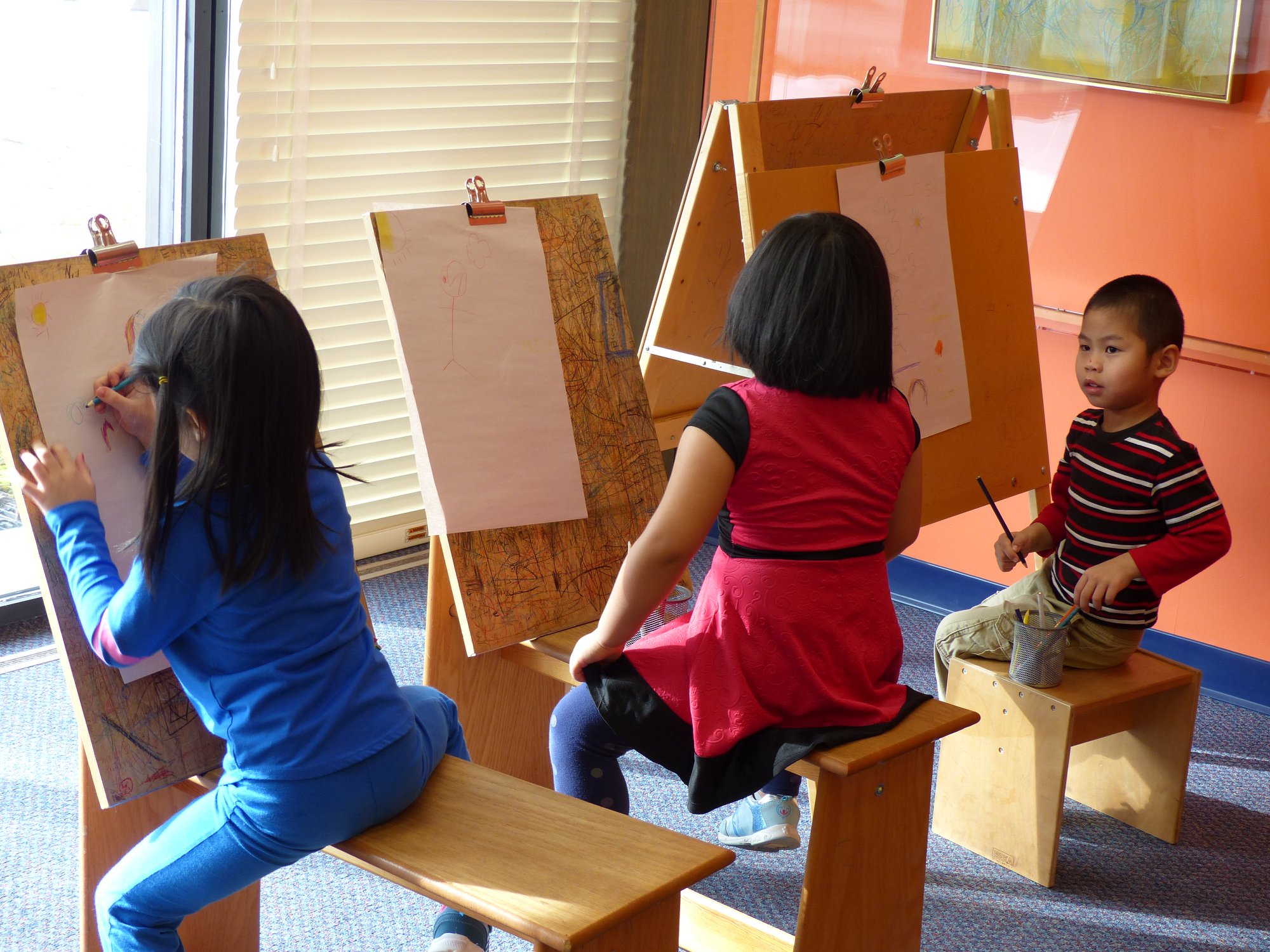 children drawing on easels