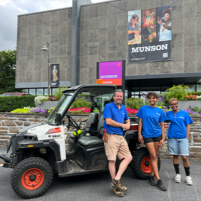 maintenance crew smiling and standing in front of museum