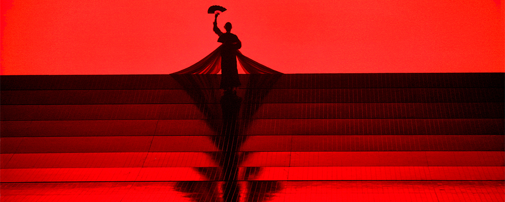 person on stage with red backdrop