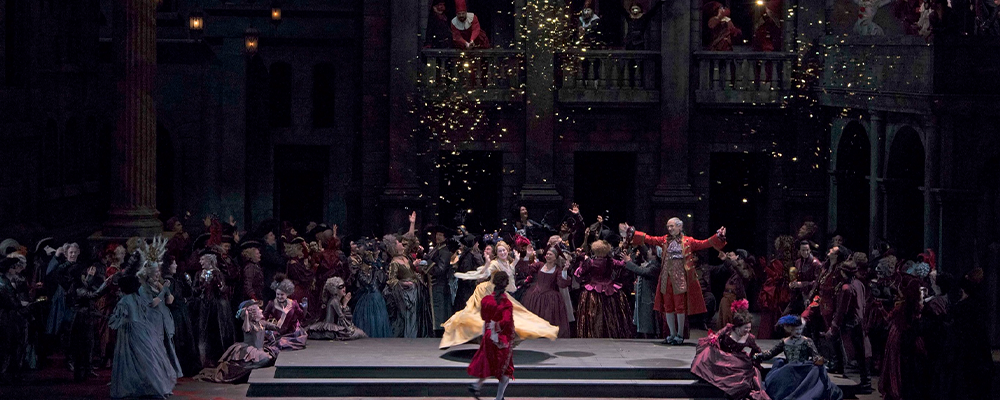 woman in yellow dancing on stage with crowd around them