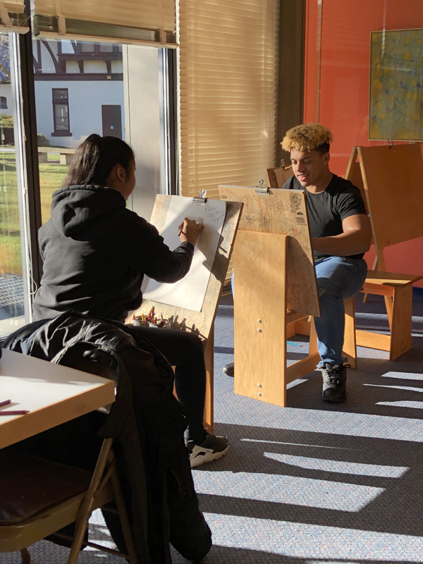 Young Adults drawing on easels