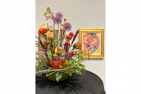 floral display with artwork behind it