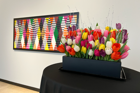 floral display with artwork behind it