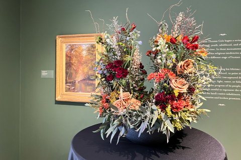 floral display with artwork behind it