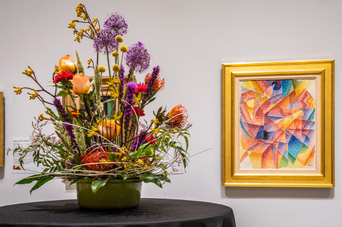 floral display with artwork behind it